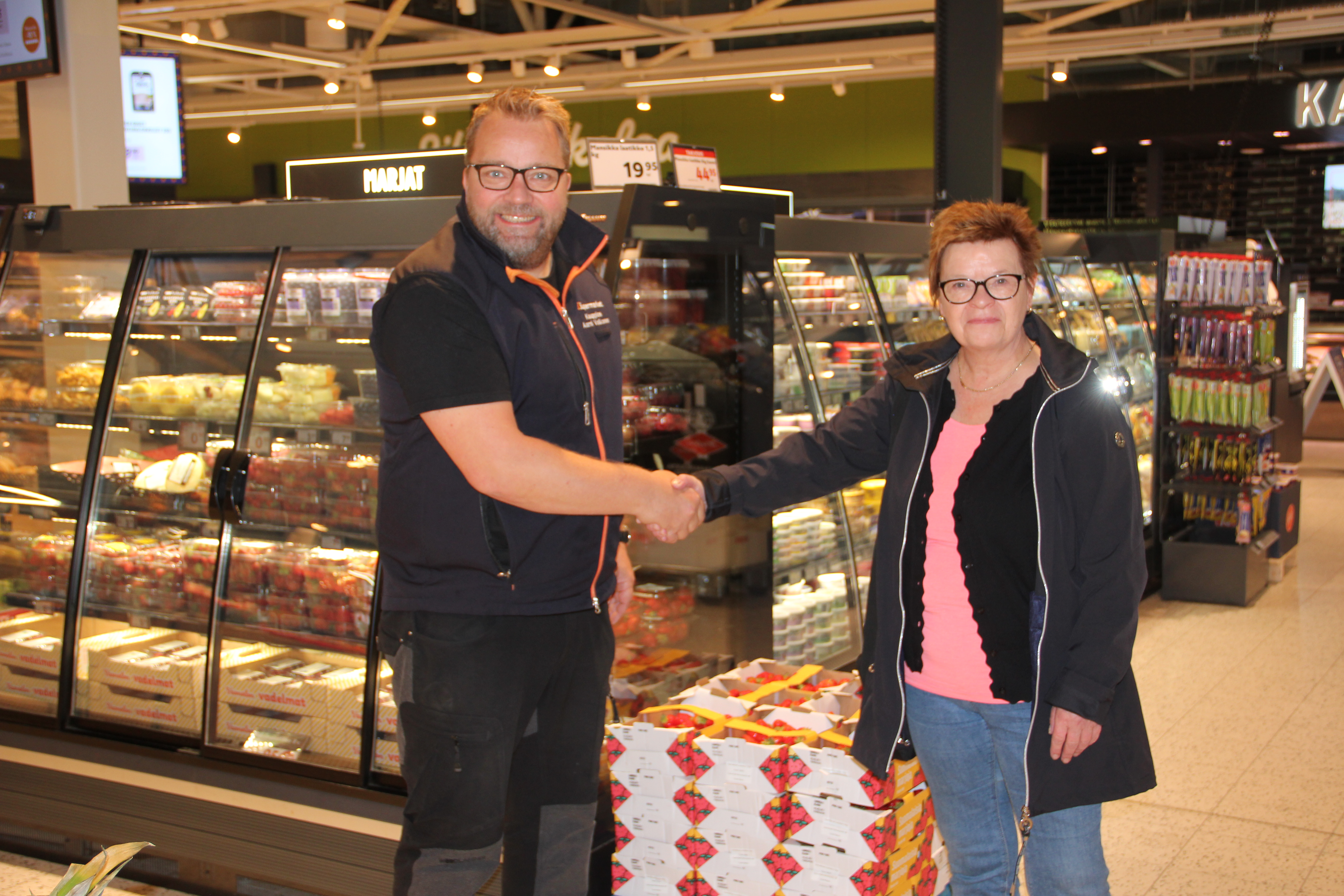 Tiedotteessa mainitut Aarni Valkonen ja Merja Ahola kättelevät K-Supermarket Kittilän sisällä.