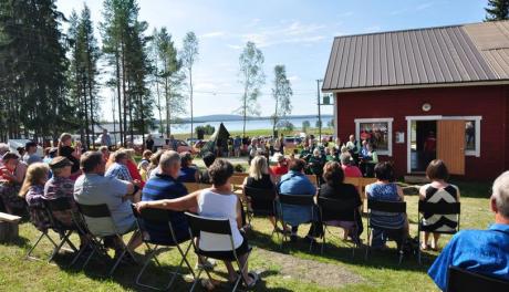 Paljon ihmisiä istumassa ulkona kesäpäivänä