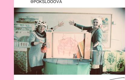 Kaksi naista seisoo hymyillen lavasteen edessä, jossa lukee "Poksloova". 