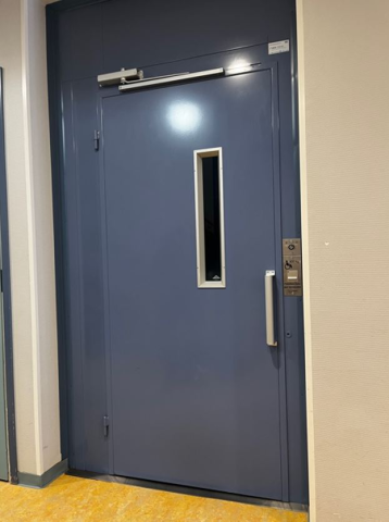 Hissin ovi on sininen ja seinät ympärillä vaaleat.