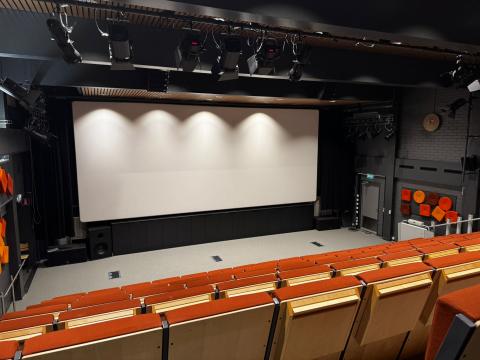 Kino Ylärin katsomon penkkejä ja valkokangas.