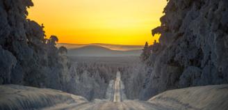 Auringonlasku,talvinen tie Lapissa ja tunturi taustalla, kuva Lapin materiaalipankista
