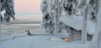 Talvimaisema, kuvassa suksenjäljet ja sukset, kota ja tulet