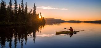 Kuvitskuva, meloja järvellä kesäisessä auringonlaskussa