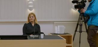 Nainen istuu yksin työpöydän ääressä
