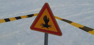 Varoitusmerkki rannassa ja sulkunauha.