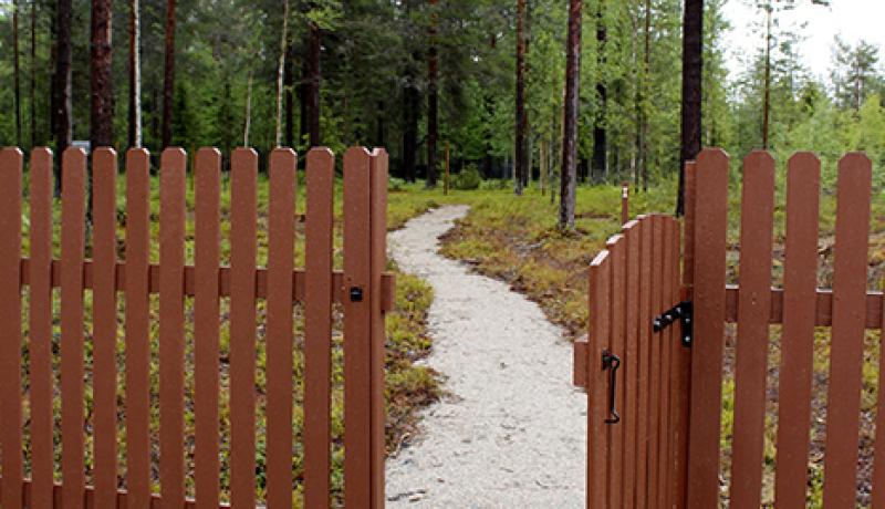 Kittilän pieneläinhautausmaan portti ja hautausmaan käytävä, taustalla alueen metsää.