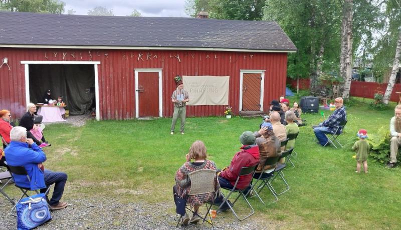 Kesäisellä pihalla istuu ihmisiä