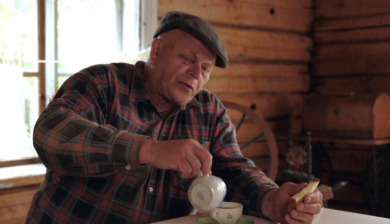 Mies kaataa maitoa kahviinsa ja pitelee kädessään kampanisua