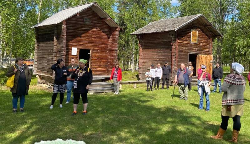 Ihmisiä kotiseutumuseon aittojen edessä